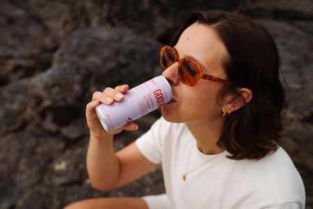 A woman drinking a CBD drink