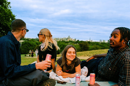 People sat in a field with cans of Goodrays CBD drinks